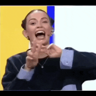 a woman is making a funny face and pointing at the camera with her fingers .