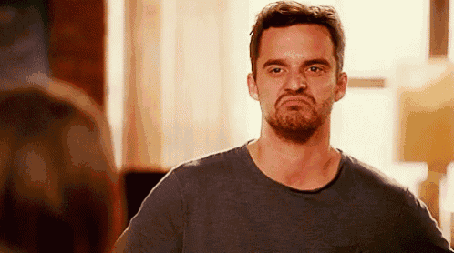 a man with a beard is making a funny face and looking at the camera .