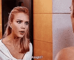 a woman is talking to a man in front of a mirror and asking him if he is alright .