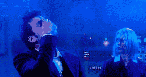 a man in a suit is covering his face with his hand in front of a blue background
