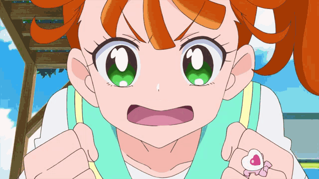 a girl with orange hair and green eyes is wearing a heart shaped ring on her finger