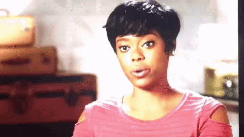 a woman in a pink shirt is making a funny face .