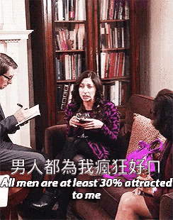 a woman is sitting on a couch talking to a man who is taking notes