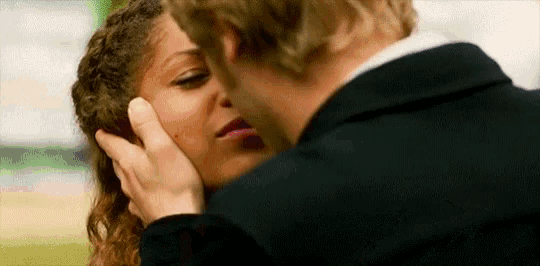 a man is touching a woman 's forehead while they are kissing .