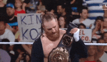 a man in a wrestling ring with a sign that says ' kin ko ' on it