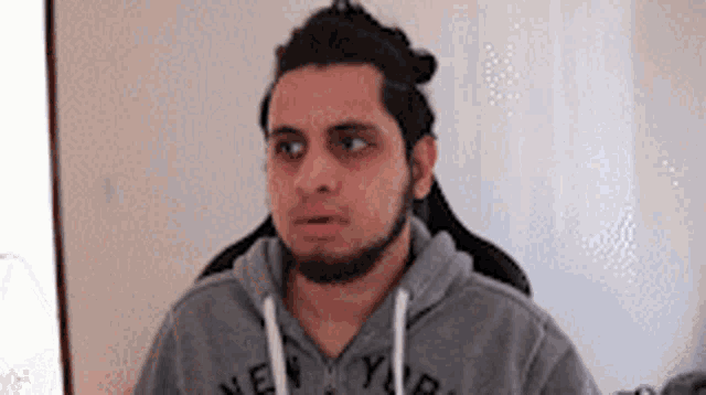 a man with a beard wearing a new york hoodie
