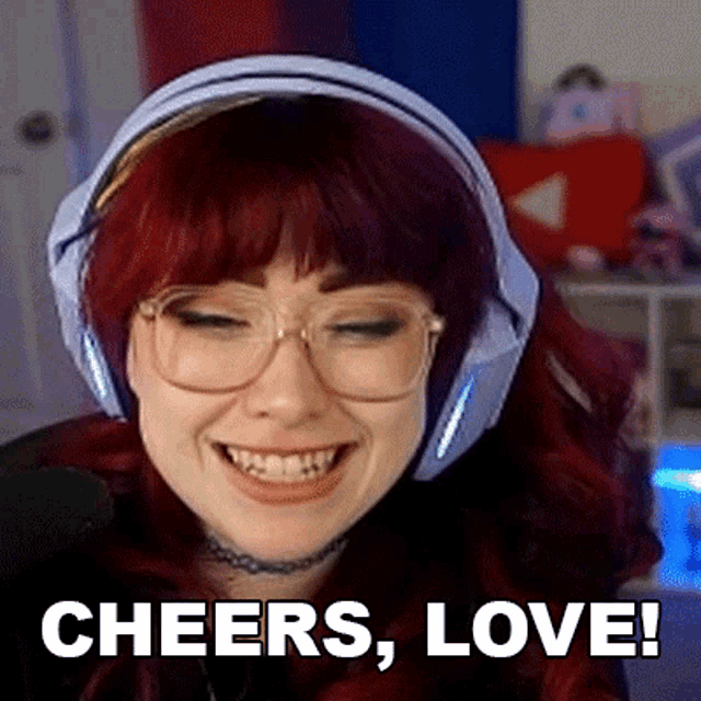 a woman wearing headphones and glasses is smiling and saying cheers , love !