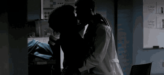 a man and a woman are kissing in front of a whiteboard that says college