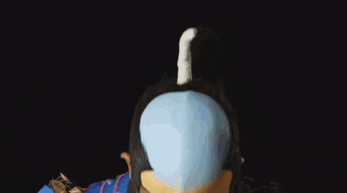a man holds a blue sword in front of his eyes