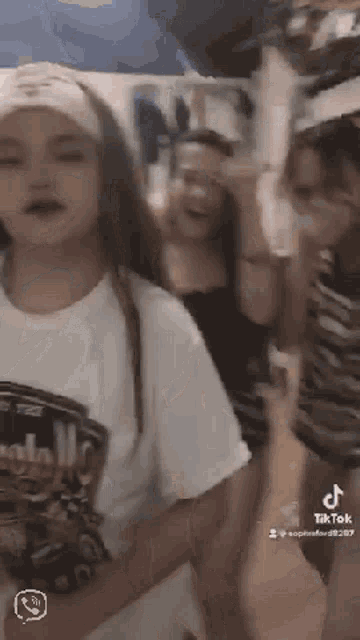 a group of young women are standing next to each other and laughing .