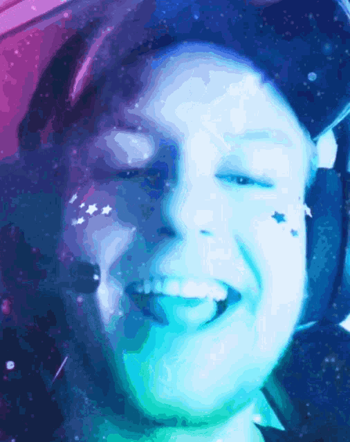 a person with stars on their face is smiling and wearing a helmet