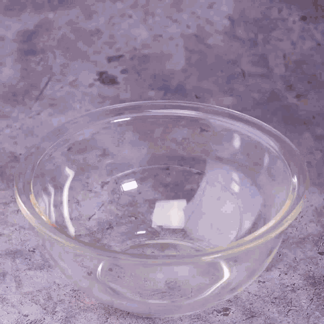a bowl of sugar is being poured into another bowl