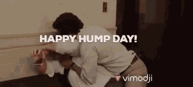 a man is kneeling down next to a woman and the words happy hump day are above him .