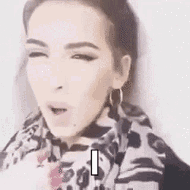 a woman wearing a scarf and earrings is making a funny face and says fuckin .