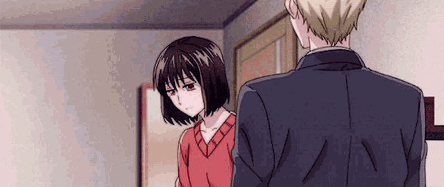 a man in a suit and a woman in a red sweater are standing next to each other