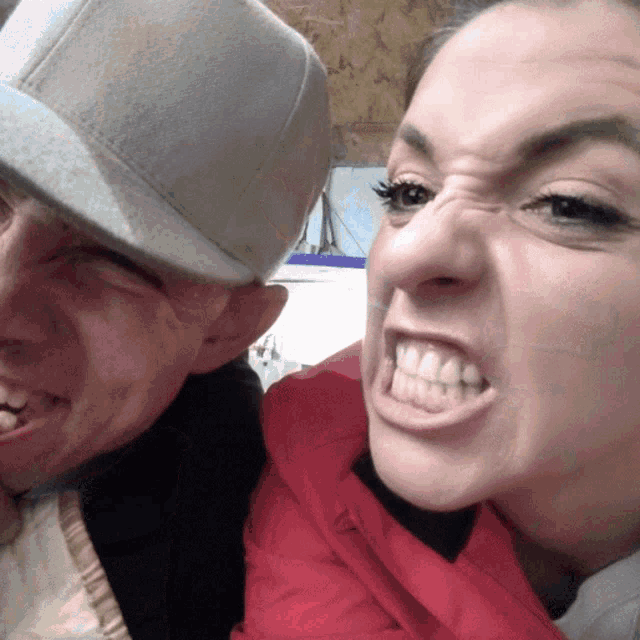 a man and a woman are posing for a picture and the woman is making a face