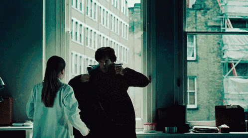 a woman in a lab coat stands next to a man in a black coat
