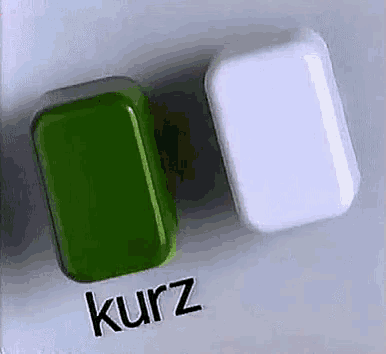 a green and a white bar of soap are sitting on a table .