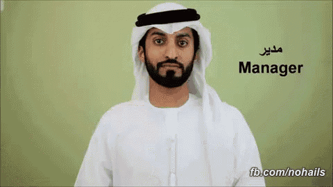 a man with a beard is wearing a white shirt and a white head scarf with the word manager written on it
