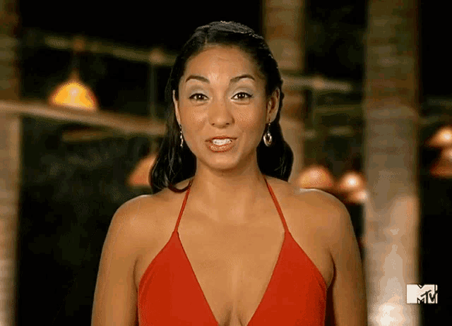 a woman in a red top is standing in front of a mtv sign