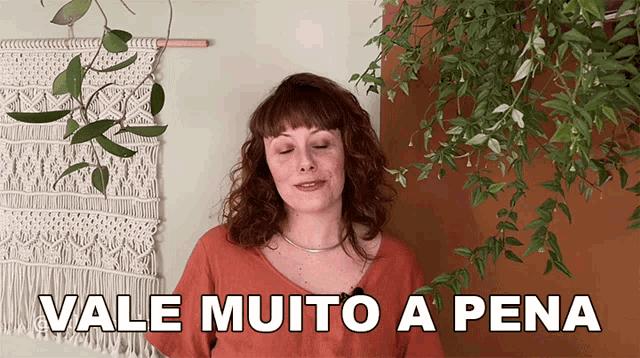 a woman says vale muito a pena in front of plants