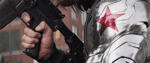 a close up of a person holding a gun with a red star on it .