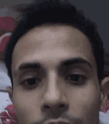 a close up of a man 's face with his eyes closed and a beard .