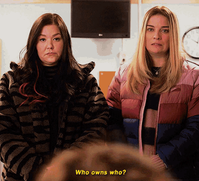 two women are standing next to each other with the words who owns who on the bottom