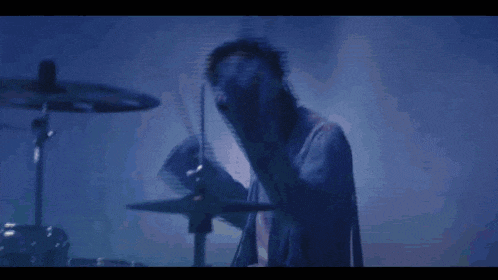 a blurry picture of a person playing drums in a dark room