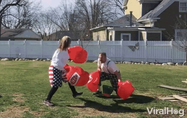 a man and a girl are fighting with red balloons that say knockout