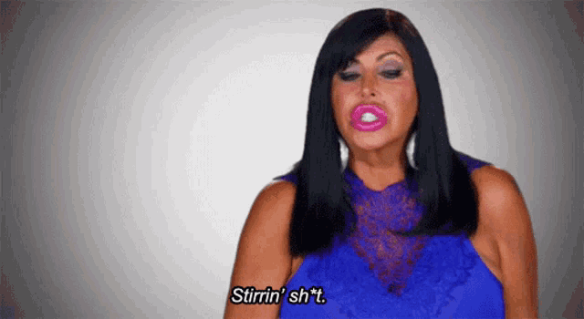 a woman in a blue dress is making a funny face and says stirrin ' sh * t .