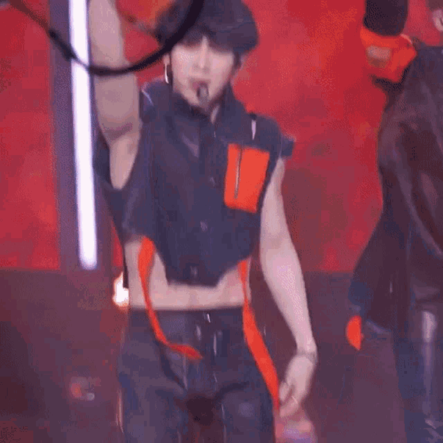 a man without a shirt is holding a hula hoop in his hand on a stage .