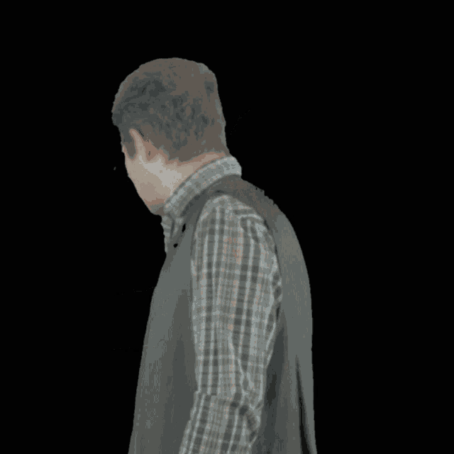 a man wearing glasses and a plaid shirt has ogabno written on the bottom of his chest