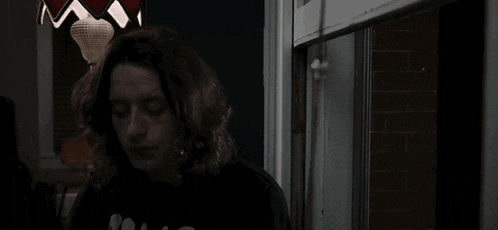 a woman is smoking a cigarette in a dark room