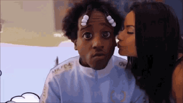 a woman is kissing a man on the cheek who is wearing a blue jacket that says milford on the side