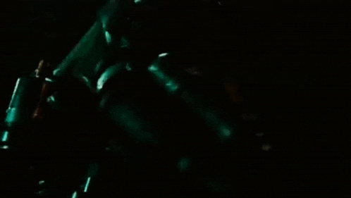 a close up of a man in a suit with a light on his chest in a dark room .