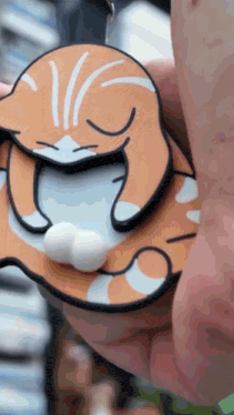 a close up of a person holding a cat key chain