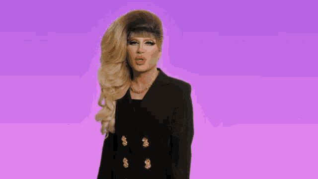 a drag queen wearing a black jacket with gold dollar signs on it