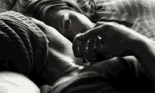 a black and white photo of a man and a woman laying in bed