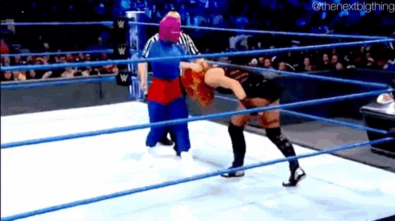 two women are wrestling in a ring with a referee in the background .