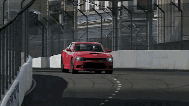 a red dodge charger is driving on a track
