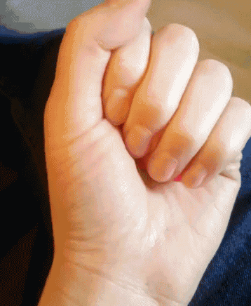 a close up of a person 's fist with their nails painted pink