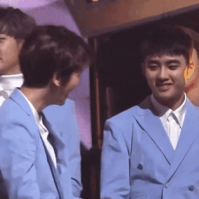 two men in blue suits are standing next to each other smiling