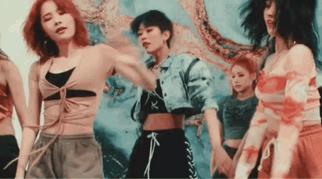 a group of young women are dancing together in front of a colorful background .