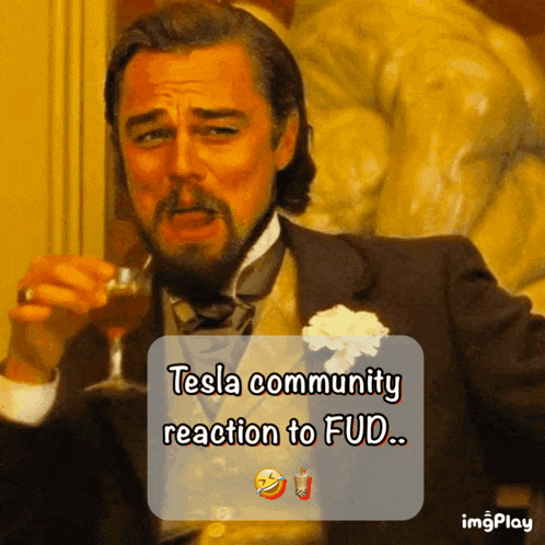 a man in a suit is holding a glass of wine and says tesla community reaction to fud ...