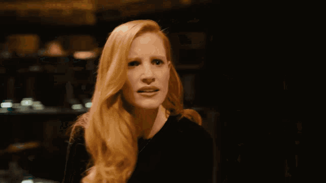a woman with red hair is making a funny face and pointing up