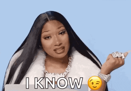 megan thee stallion is wearing a white fur coat and a smiley face on her wrist .