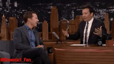 a man in a suit sits in front of a microphone with the words benedict fan on the bottom