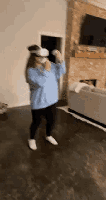 a person wearing a virtual reality headset is dancing in a living room