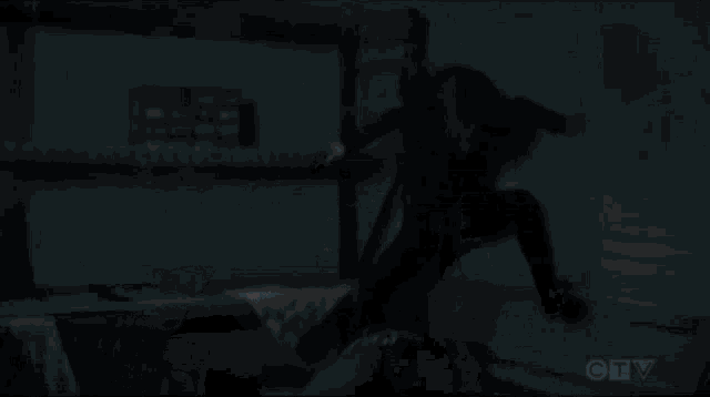 a man is kneeling on the floor with a knife in his hand .